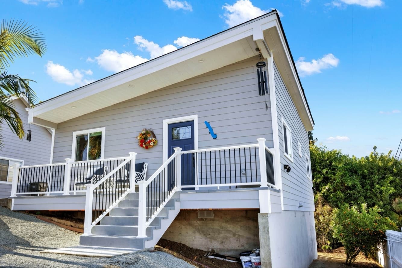 Completed detached ADU with a white porch and American-style siding, built by Casita
